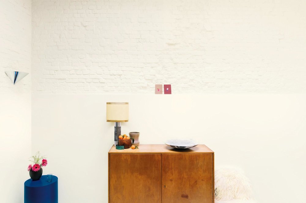 Inspiratiebeeld colora - woonkamer met witte bakstenen schouw en houten kast - colora magazine SS2021 - woonverhaal Senne & Eefje