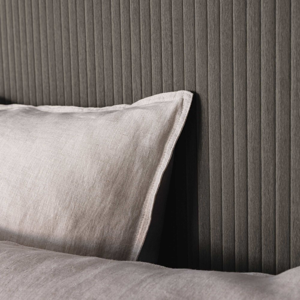 behang - slaapkamer - Caselio - Woodline - WOD106849089  - Donkerbruin - donker geribd behang, beige kussen en dekbed, textiel in linnenlook