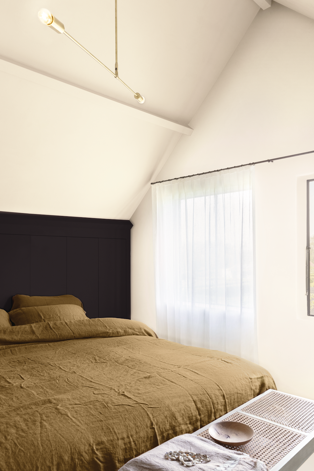 Colora-slaapkamer in het wit met zwarte accentmuur achter het bed
