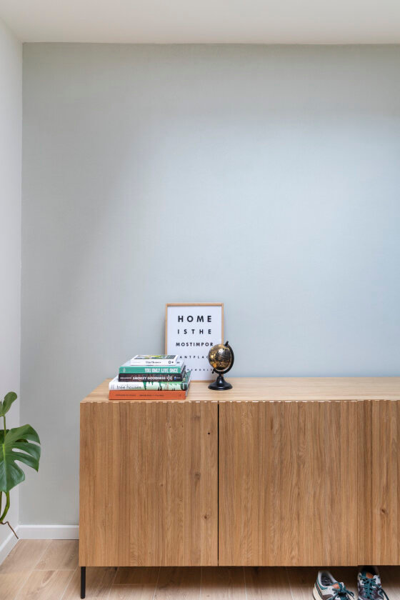 Blauwe muur met bruine dressoir kast 
