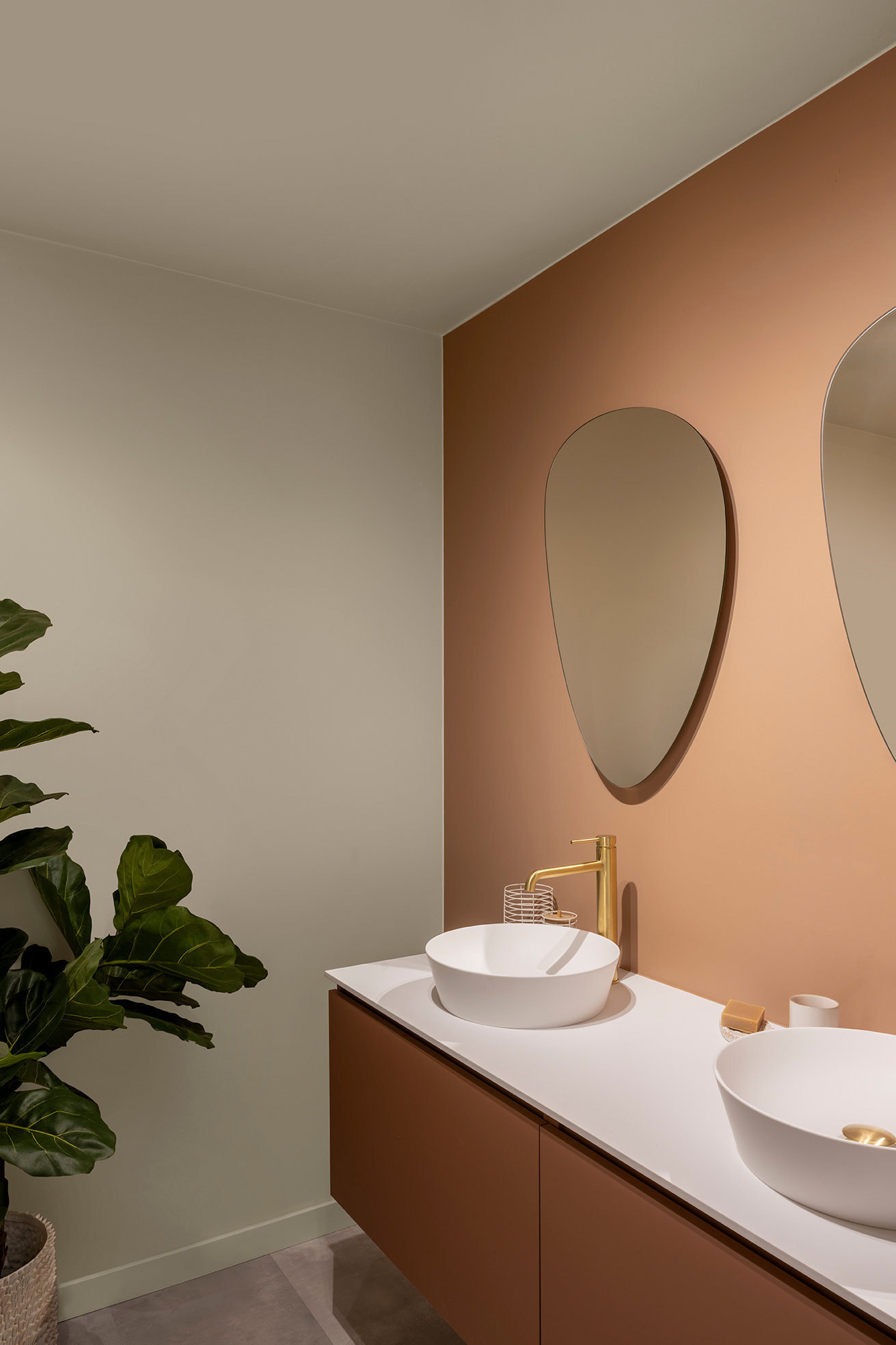 Badkamer met dubbele wasbak en warme wandkleur