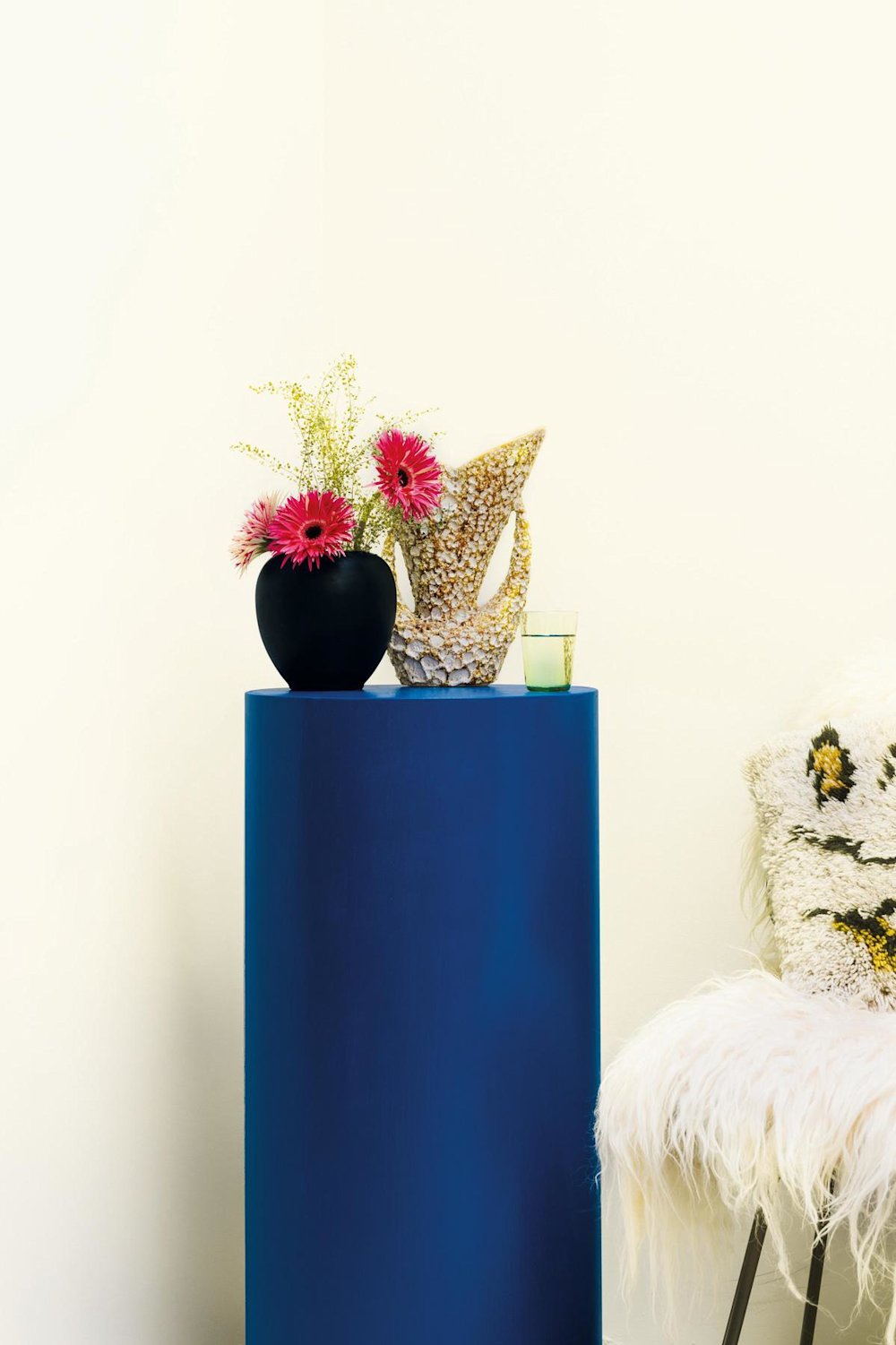 inspiratiebeeld colora - witte muur met kongingsblauw kastje en bloemen - colora magazine SS2021