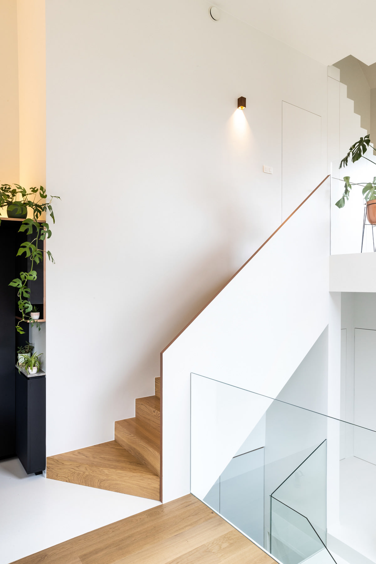 woonverhaal van karen- trap met verlichting aan de muur en planten