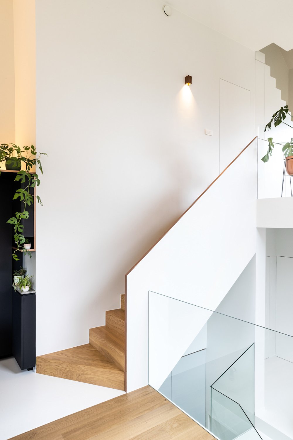 woonverhaal van karen- trap met verlichting aan de muur en planten