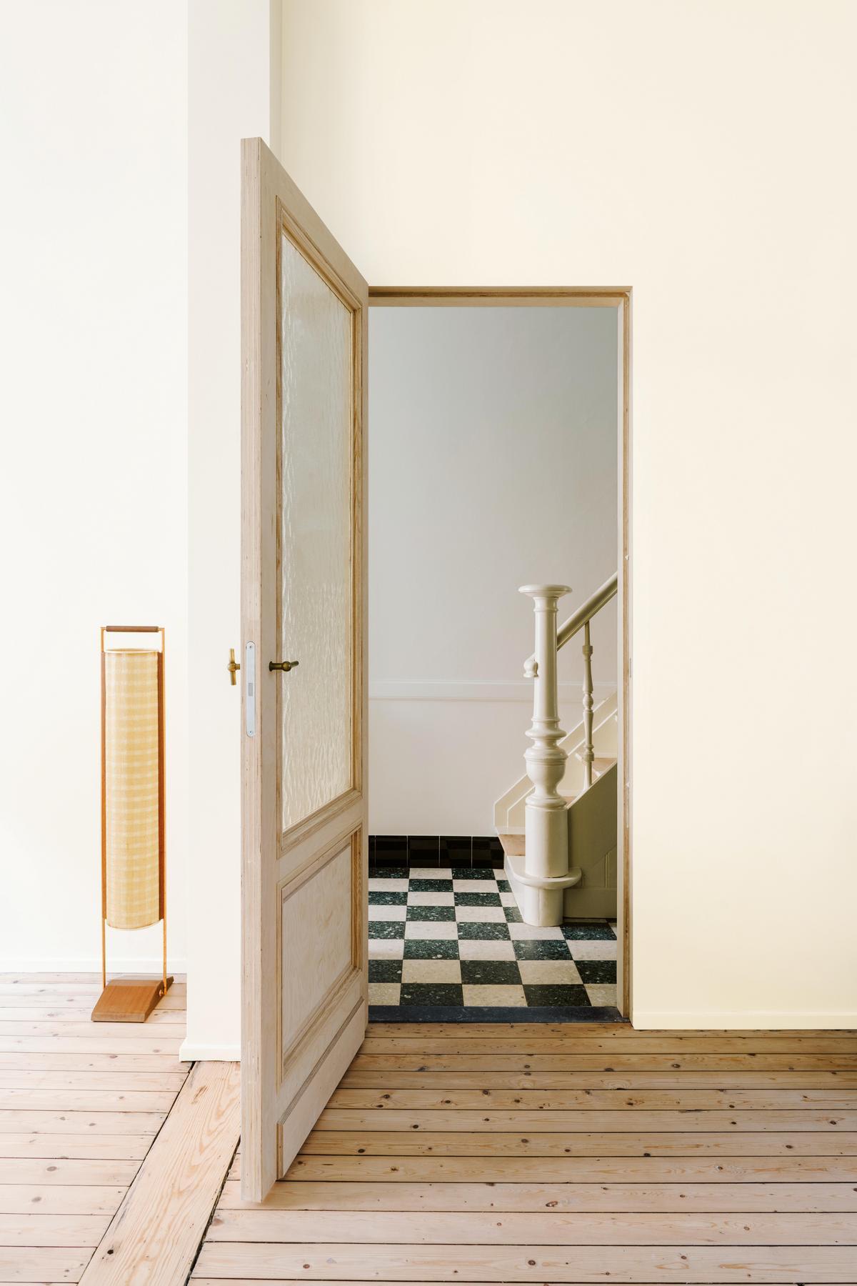 Inspiratiebeeld colora - off-white woonruimte met zicht op de trap en geruite vloer - colora magazine SS2021 - woonverhaal Senne & Eefje