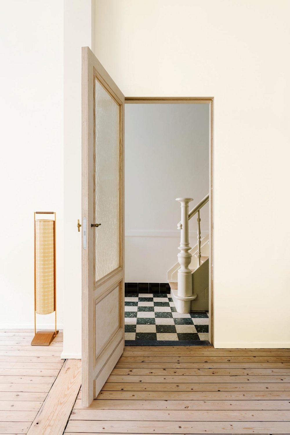 Inspiratiebeeld colora - off-white woonruimte met zicht op de trap en geruite vloer - colora magazine SS2021 - woonverhaal Senne & Eefje