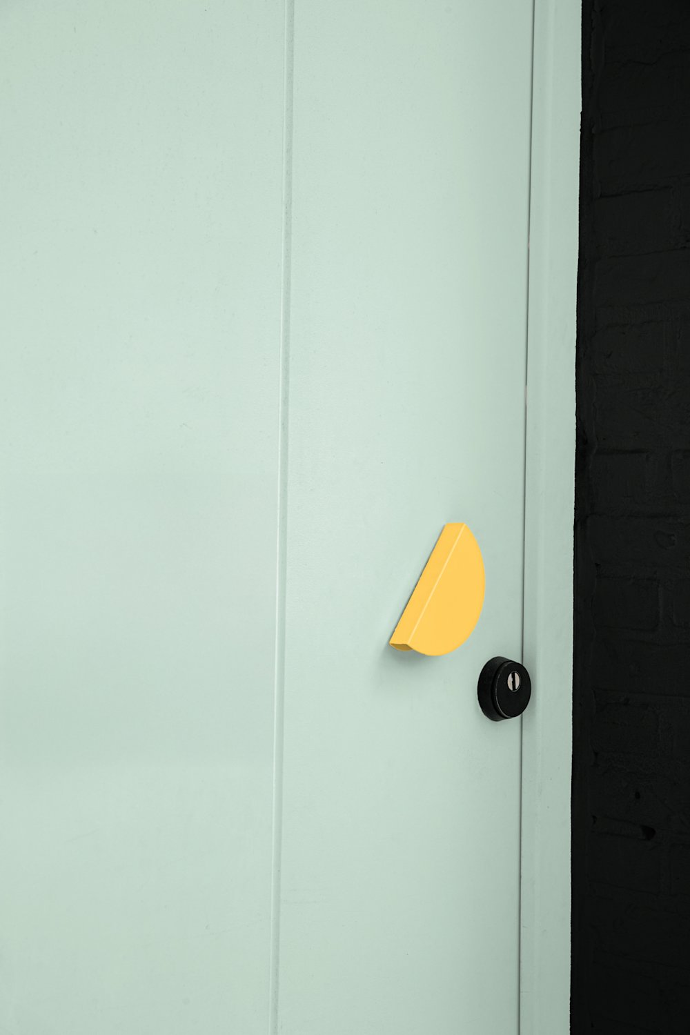 buimu - gevel - zwart - muntgroen deur - geel deurknop - Matineau - detailbeeld deur - coloramagazine