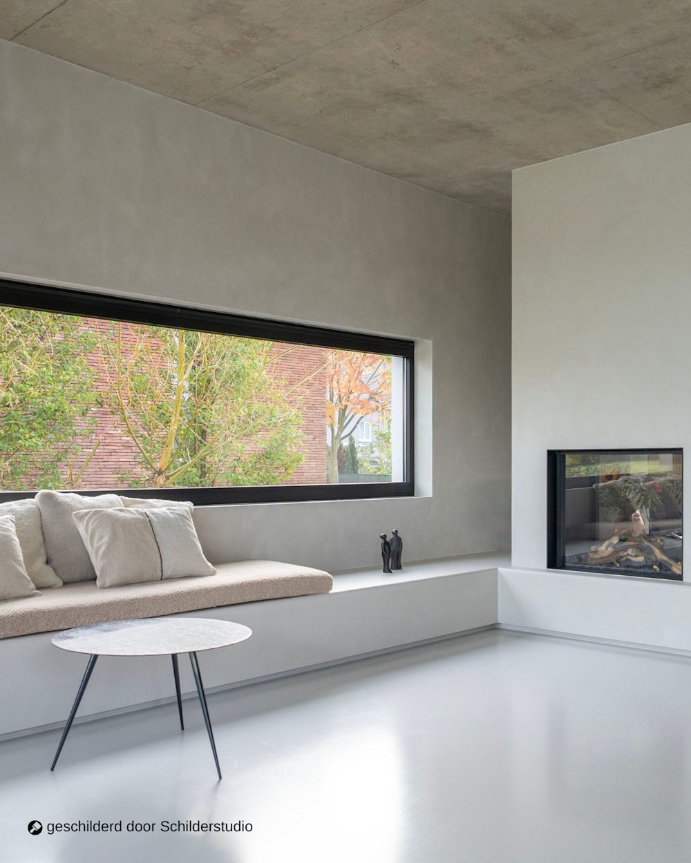 Leefruimte met zitruimte en open haard en accentmuur in Calco Original CC 18 pale moon geschilderd door Schilderstudio