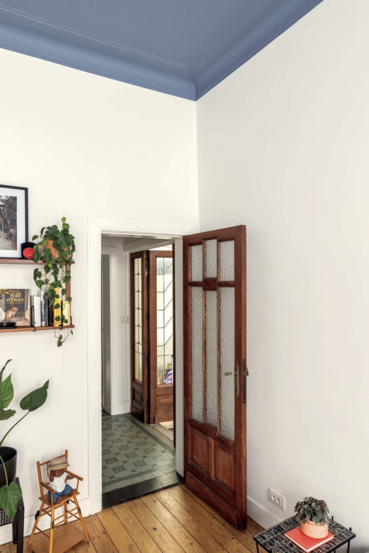 colora inspiratiebeeld - woonkamer met witte muren, blauw plafond, houten vloer en houten deur