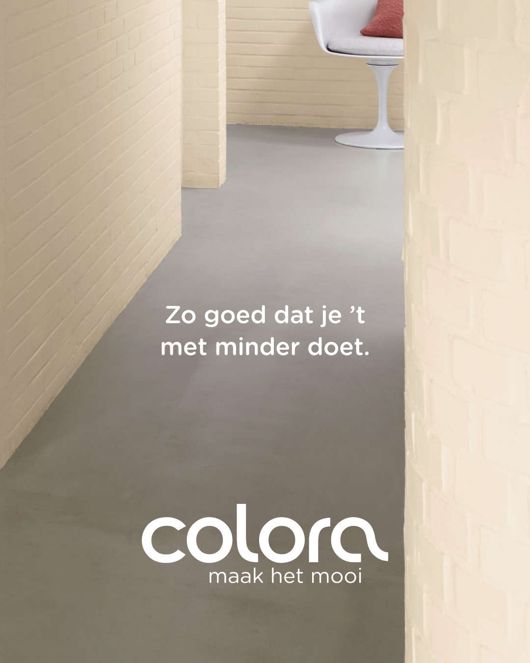 Minimalistisch interieur met lichtgekleurde bakstenen muren, grijze vloer en een witte stoel. Tekst luidt: "Zo goed dat je 't met minder doet. colora maak het mooi.
