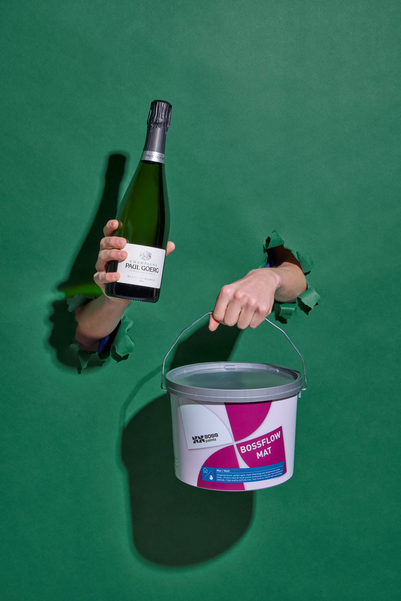Een fles champagne giet kleurrijke rode en gele vloeistof in een glas, waardoor een dramatische plons ontstaat met verfachtige wervelingen; een kurk rust op het oppervlak vlakbij.