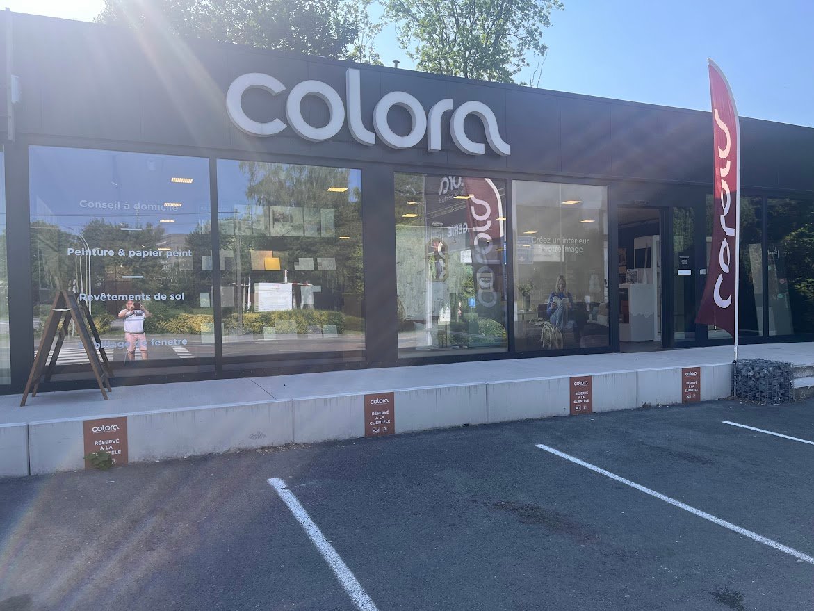 La façade de notre magasin colora à Gozéé, près de Charleroi. Façade noire avec le logo en blanc et une image colorée.