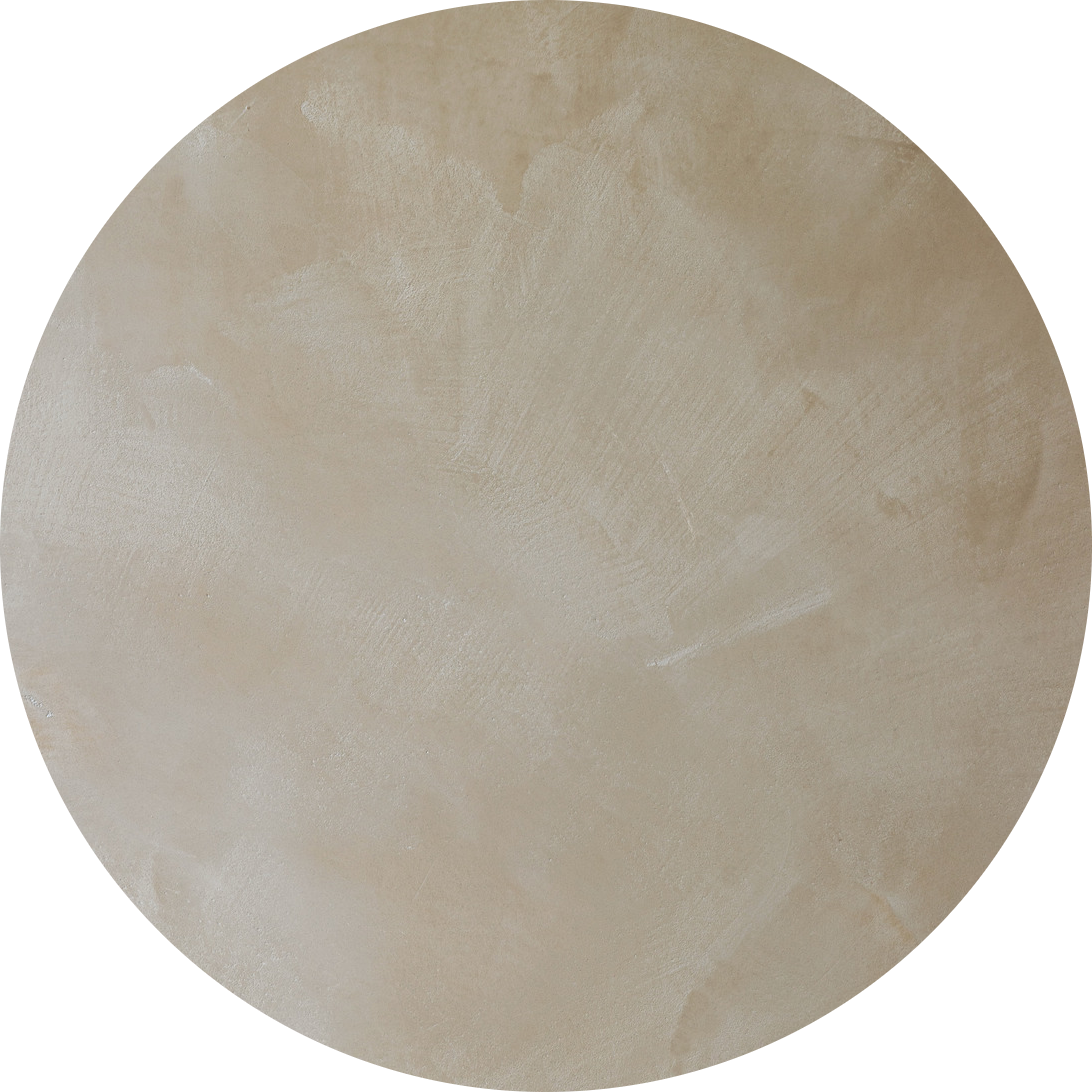 Une surface ronde de couleur beige présentant un motif texturé subtil qui rappelle un matériau brossé ou enduit.