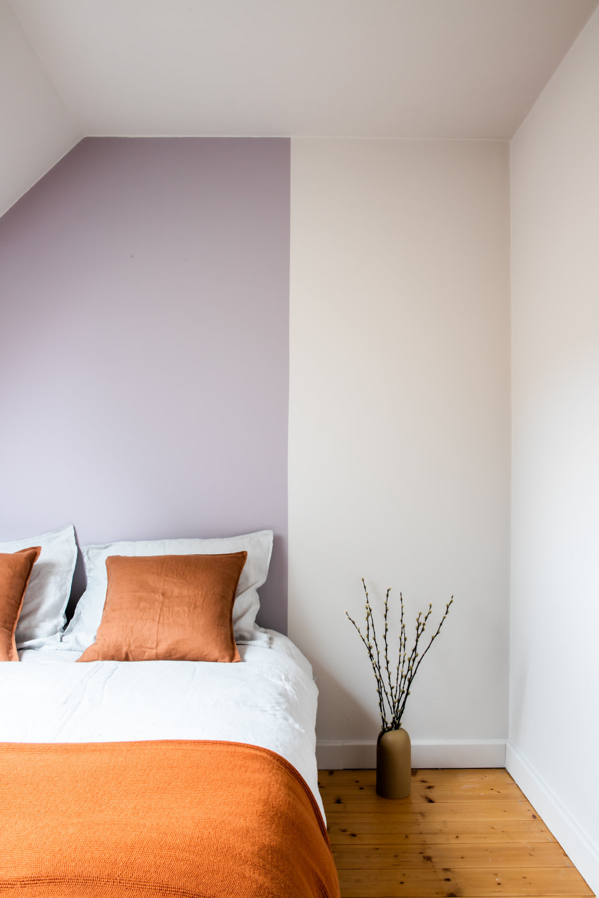 Colora-slaapkamer met accentmuur achter het bed in paars en wit