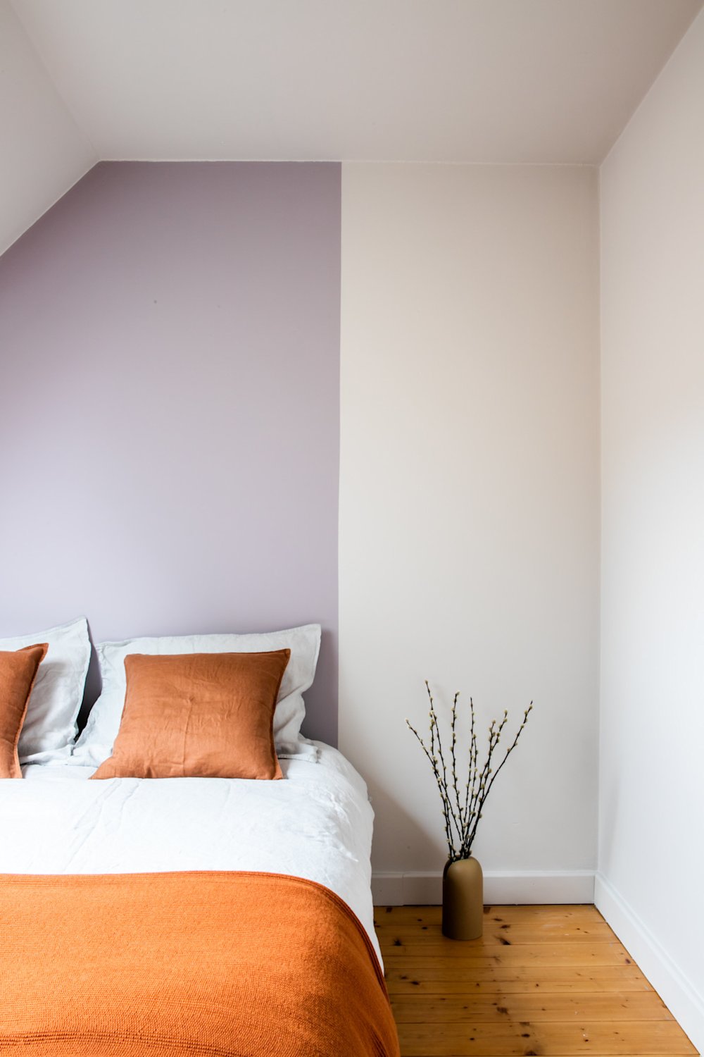 Colora-slaapkamer met accentmuur achter het bed in paars en wit