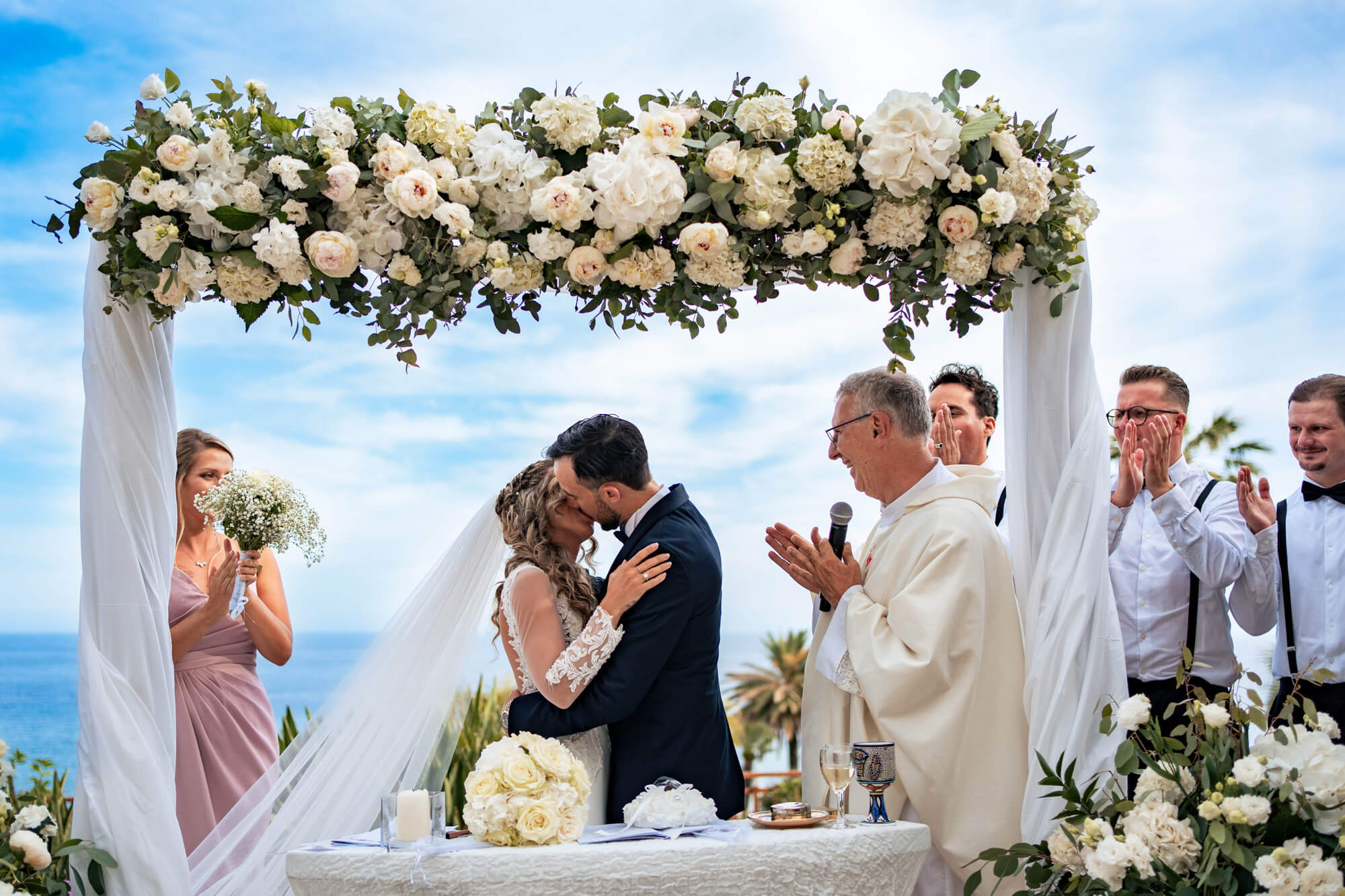 una foto del bacio tra gli sposi durante la celebrazione del loro matrimonio sulla terrazza del royal hotel di sanremo.