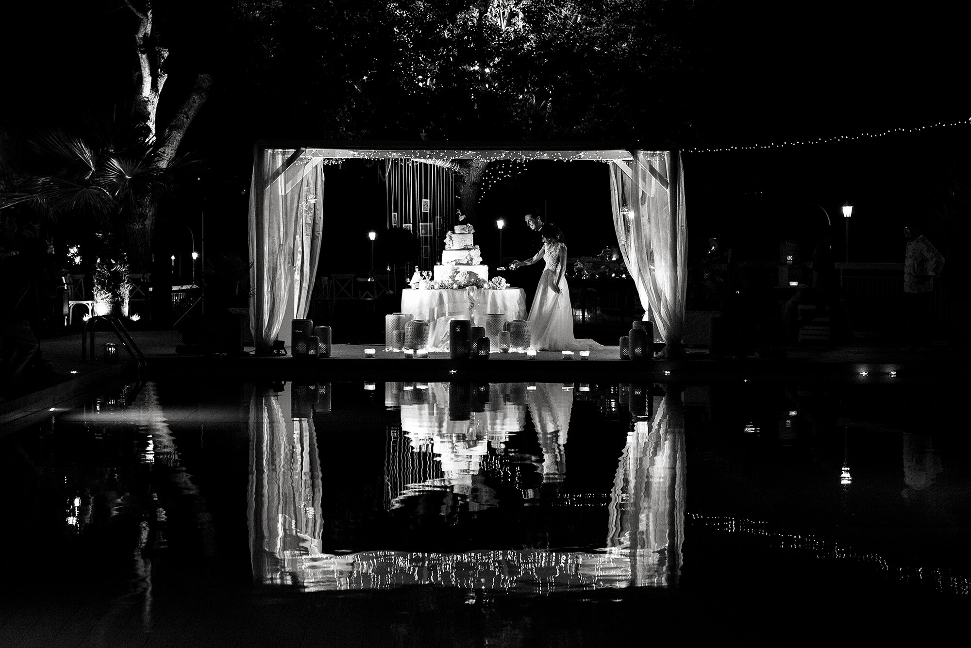 foto del taglio della torta in una location per matrimoni con piscina, matrimonio al ristorante La Femme a San Bartolomeo, in provincia di Imperia.