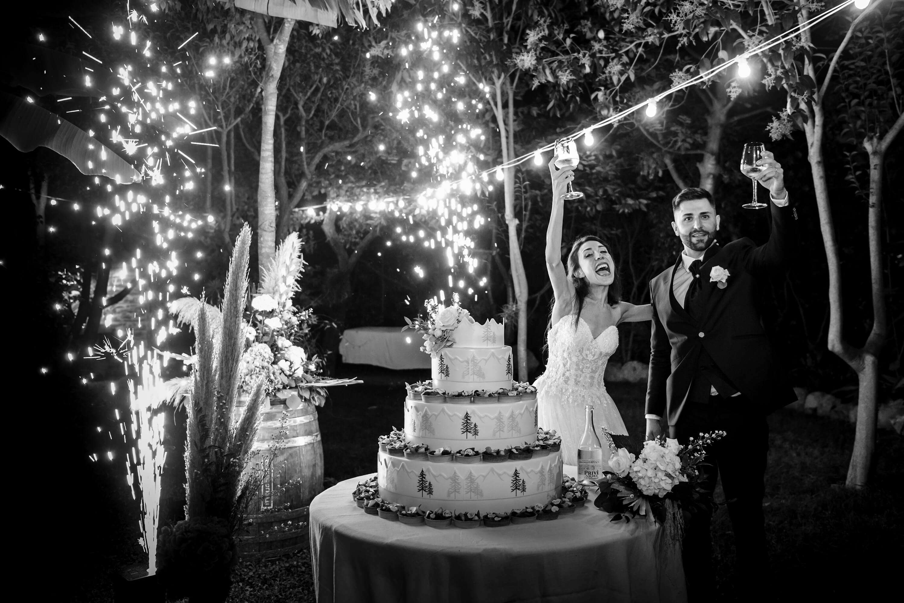 una foto del taglio della torta con sparkles (fuochi d'artificio a fontana) durante il matrimonio alla locanda del cavaliere, a San Bartolomeo al Mare