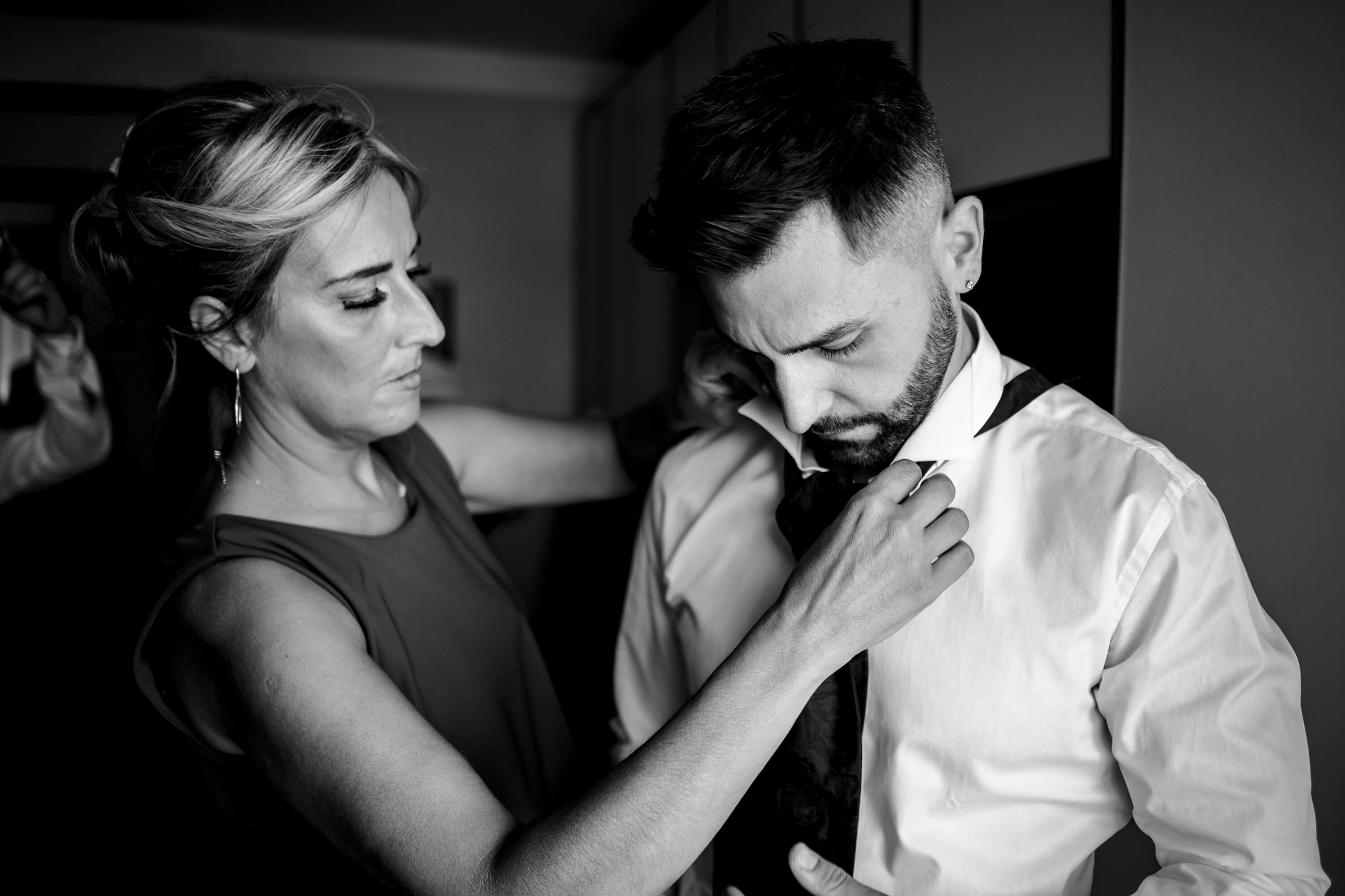 preparazione dello sposo aiutato dalla mamma a mettere la cravatta.