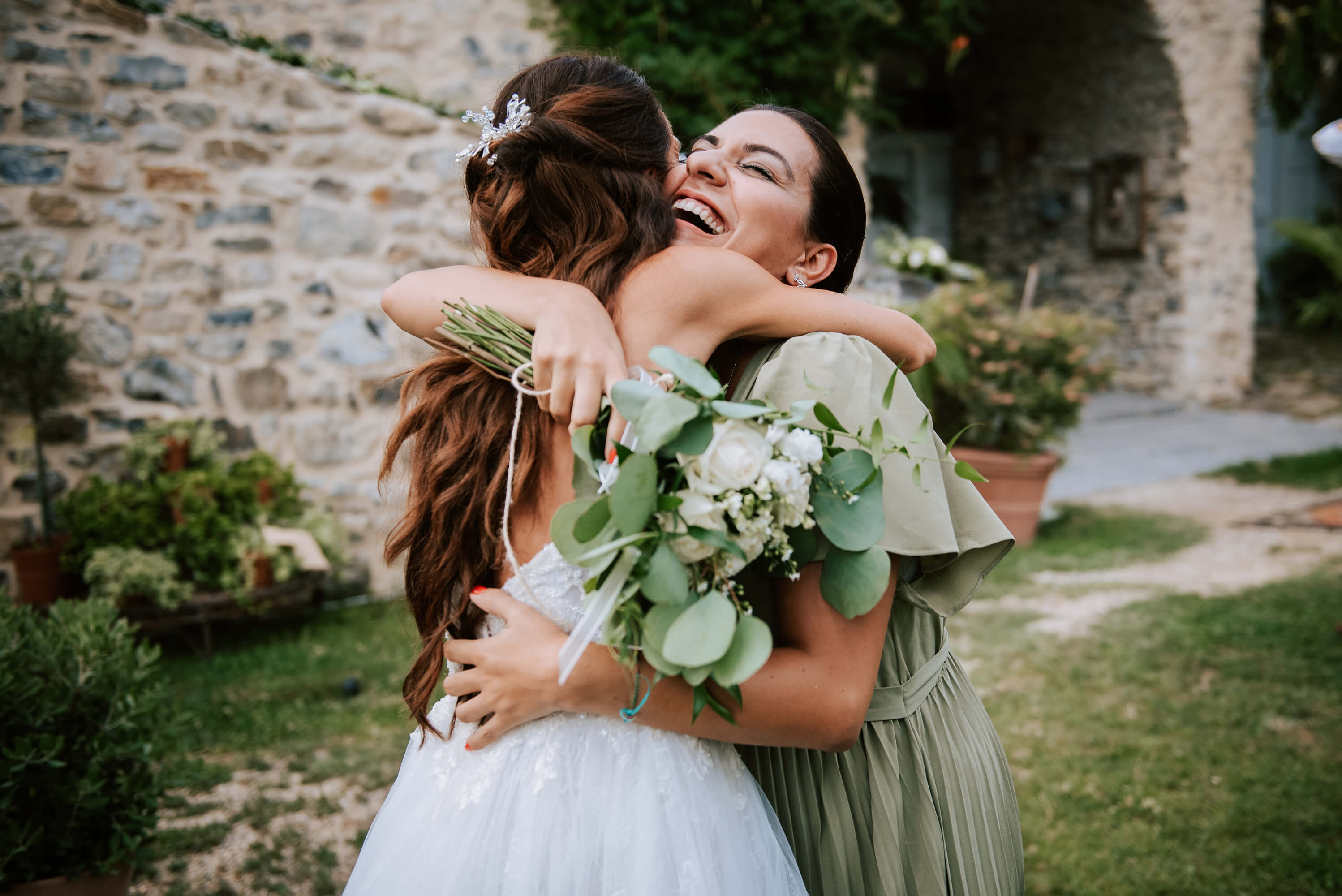 una foto dell'abbraccio della sposa con l'amica che ha preso il bouquet durante il matrimonio alla locanda del cavaliere, a San Bartolomeo al Mare