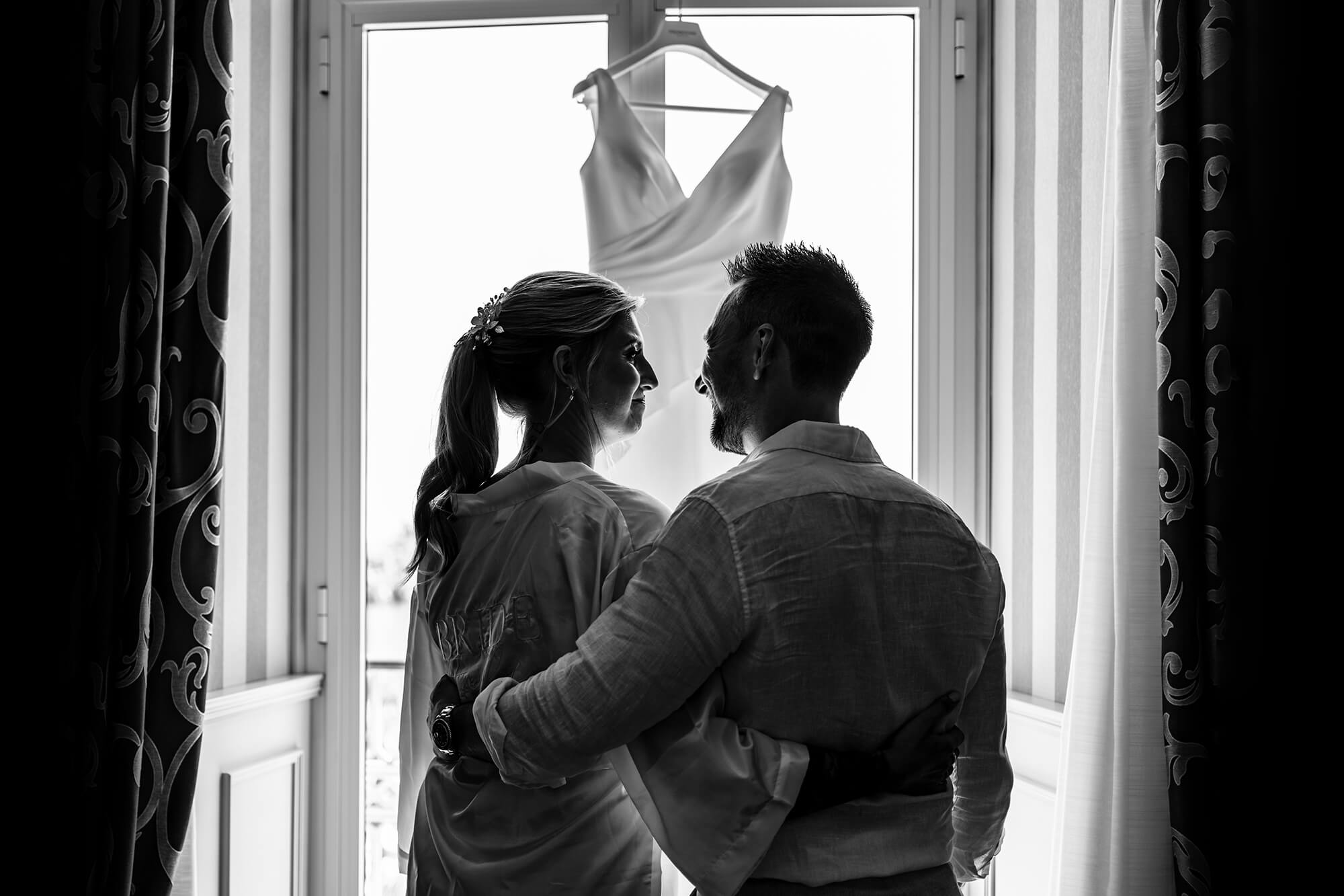 La sposa ed il fratello guardano l'abito da sposa appeso alla finestra all'hotel royal di Sanremo nel giorno del matrimonio.