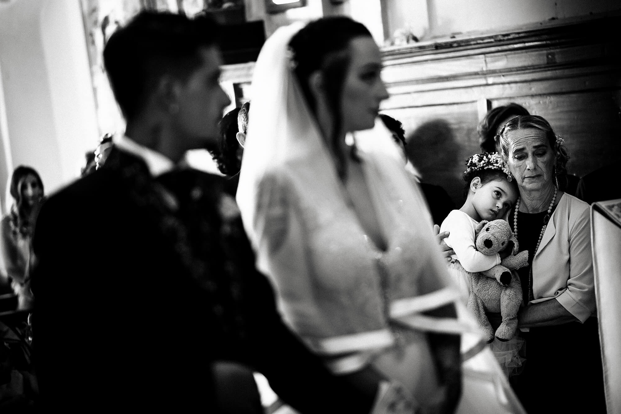 una foto di matrimonio durante una cerimonia in chiesa, la mamma e la figlia della sposa emozionate.