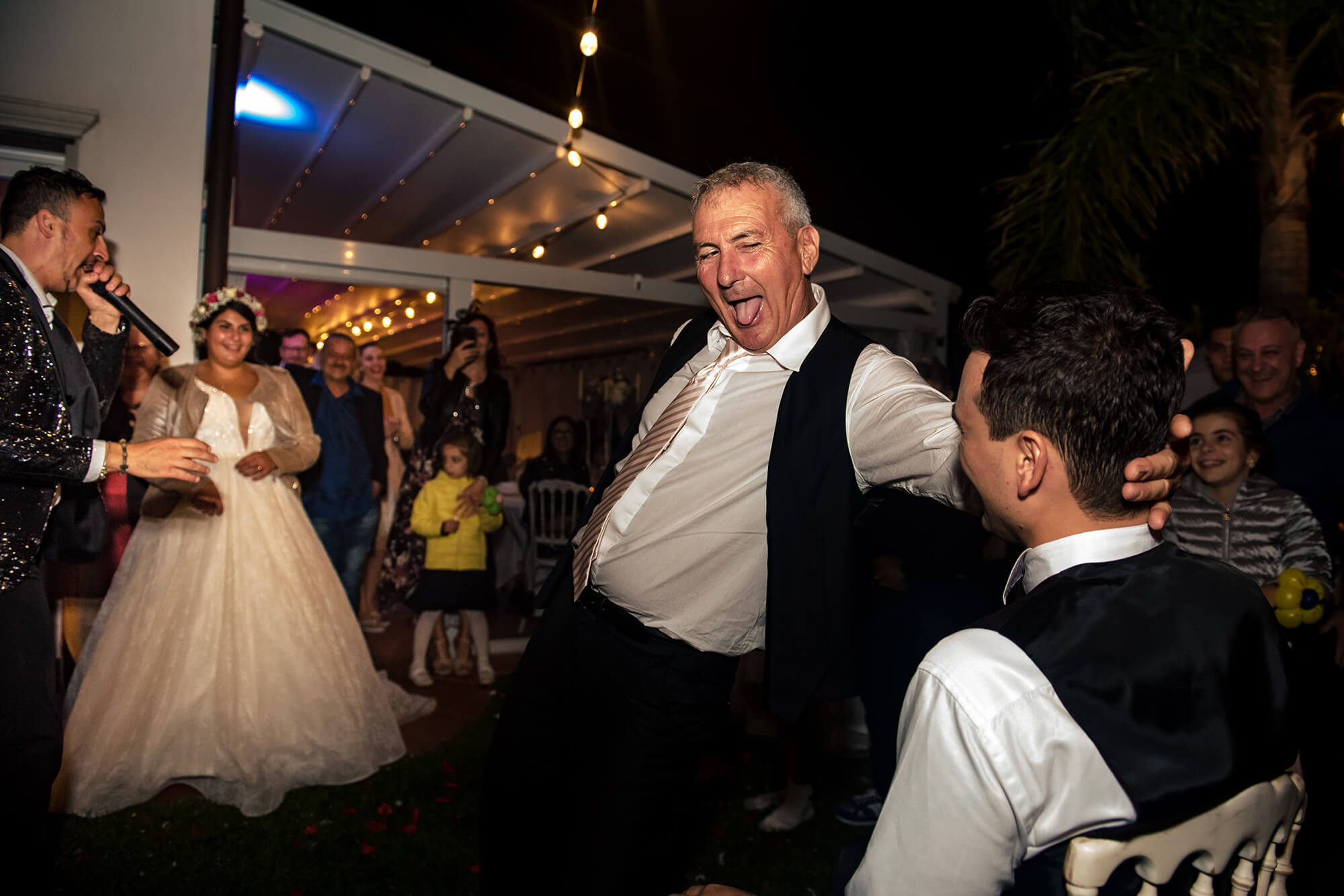 Una delle fotografie più simpatiche che abbiamo realizzato, il papà della sposa fa una lap dance allo sposo, foto realizzata in una location per matrimoni a Cipressa, in provincia di Imperia.