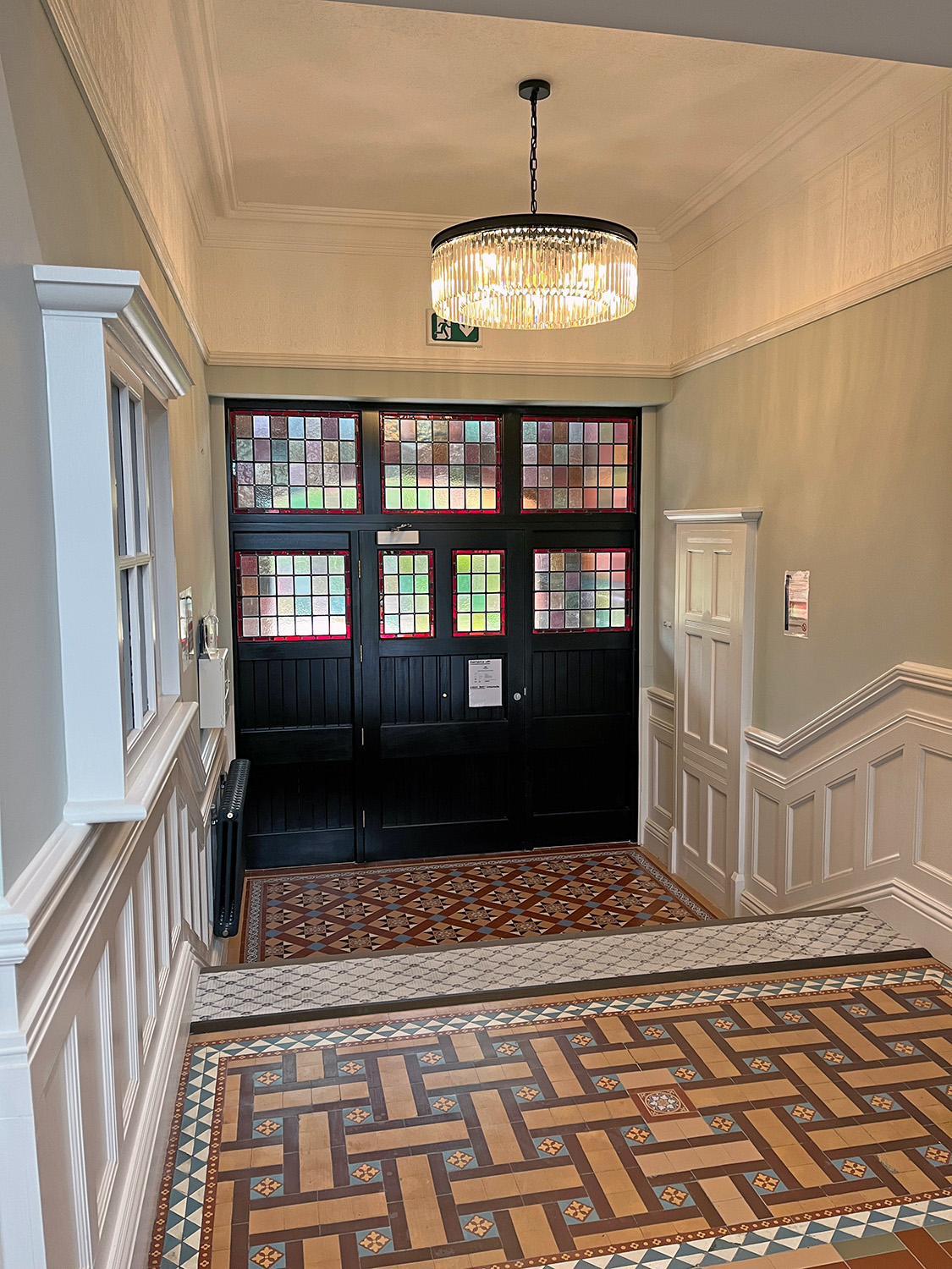 The entryway preserved the colorful tile floors, moldings, and doors with stained glass.