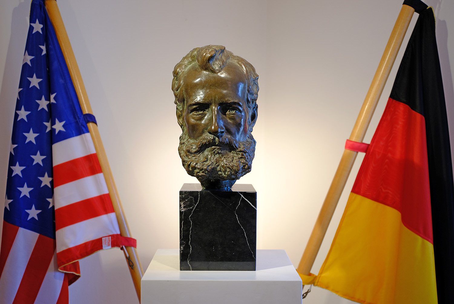 Ottmar Mergenthaler surrounded by his adopted country and home country flags of the USA and Germany