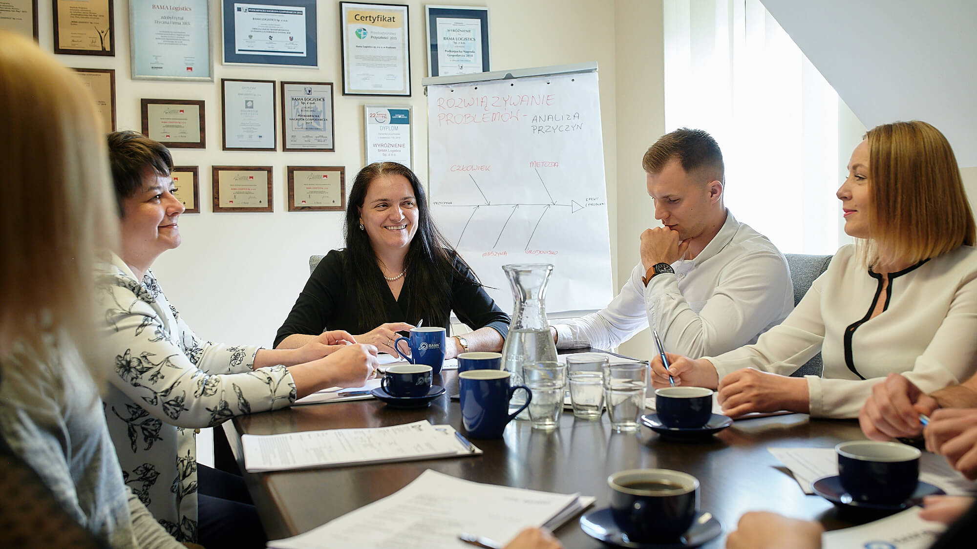 Jedna z narad Prezes Bama Logistics Agnieszki Drozd, ze swoimi współpracownikami. W tle, nagrody i wyróżnienia.