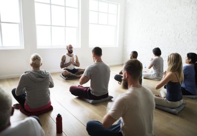 A group yoga class conducted by a male instructor.