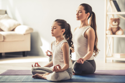 A woman and a young girl practising meditation.