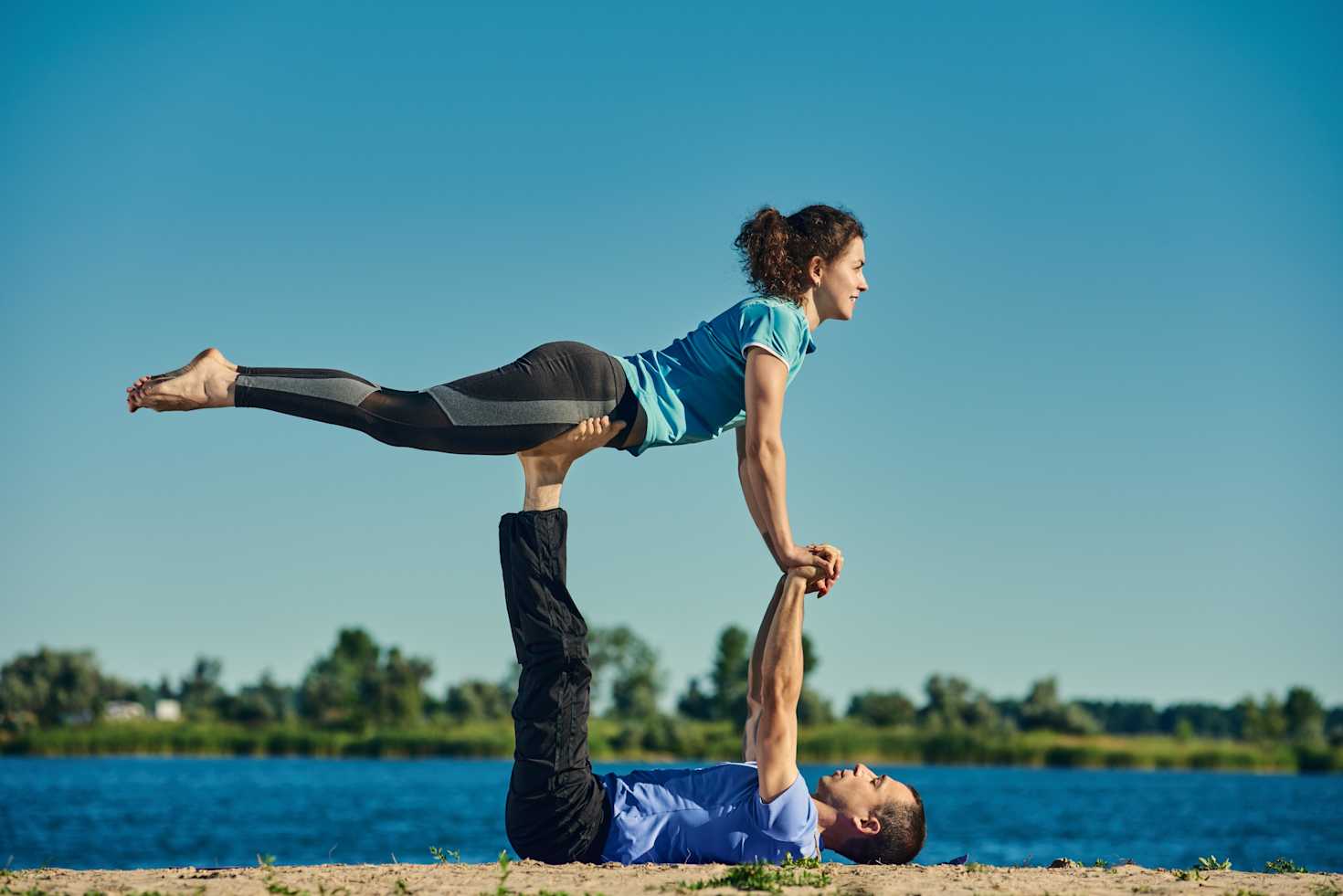 Man supporting woman in an advance yoga pose Man supporting woman in an advance yoga pose