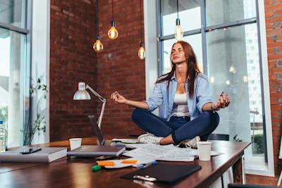 A woman sitting on the desk meditating. A woman sitting on the desk meditating.