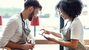 Twee sociaal ondernemers  kijken tevreden naar hun maatschappelijke verdiensten - arbeidsmarktparticipatie, sociale samenhang of klimaatverandering tegengaan