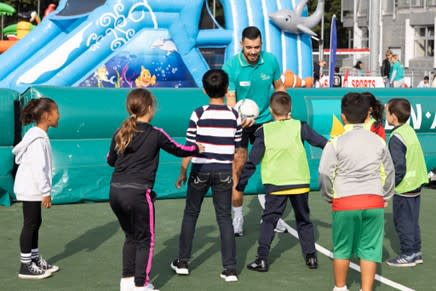 Sportende kinderen en begeleider met bal