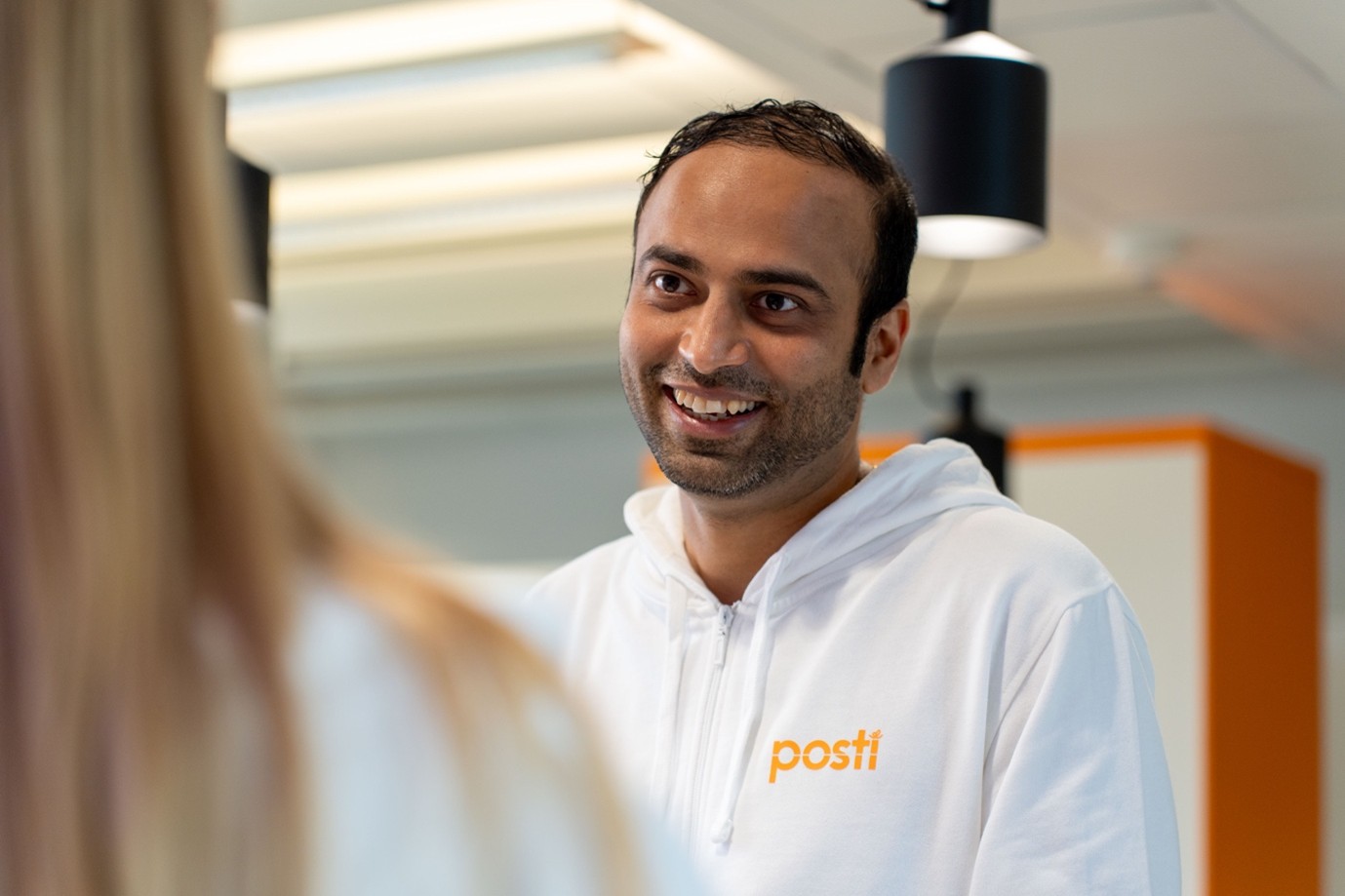 Mies pukeutunut valkoiseen Posti huppariin 