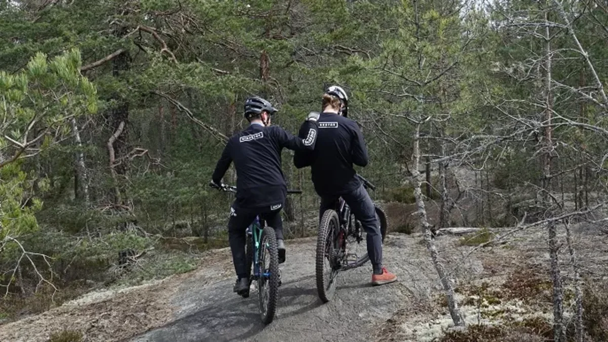 Two cyclists in a forest.