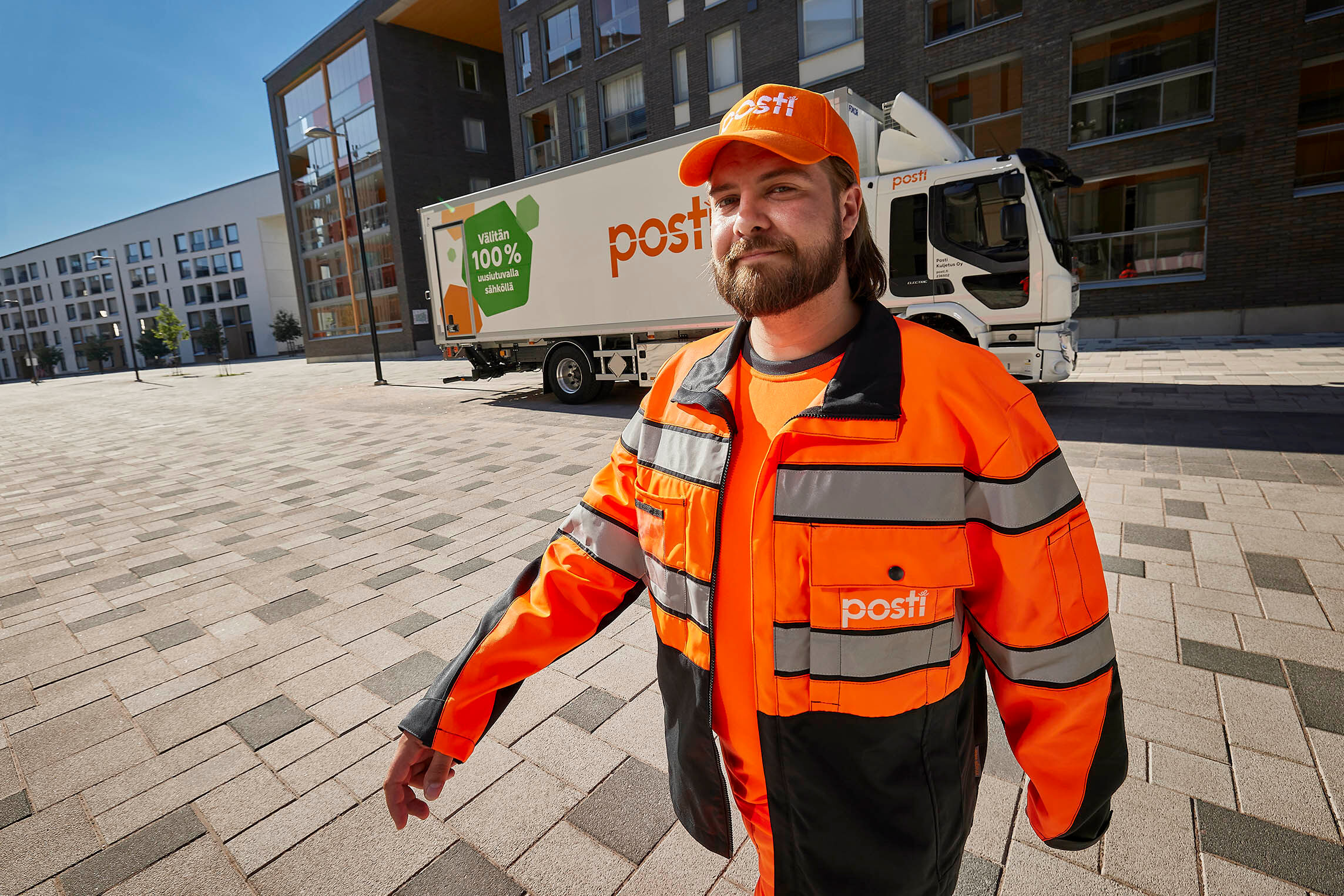 A smiling employee and a postal truck in the background.