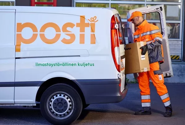 Posti's personnel taking a package out from a van.