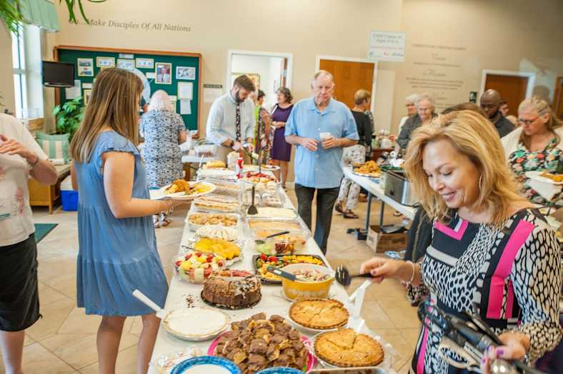 Adults having a potluck meal