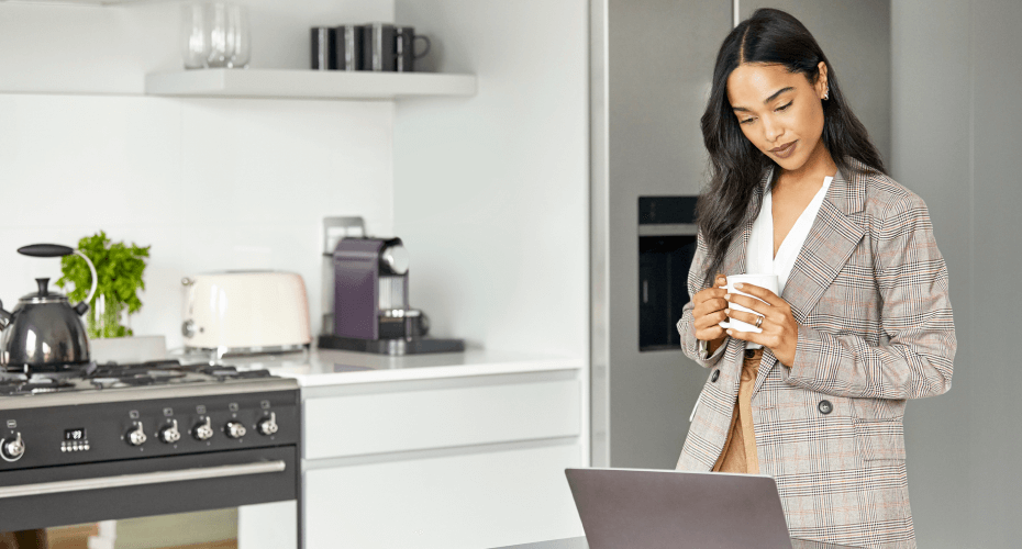 A woman looking at her laptop screen at home.