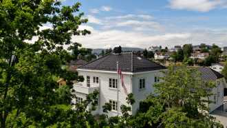 Hvitt hus med Hollander V glasert sort på taket