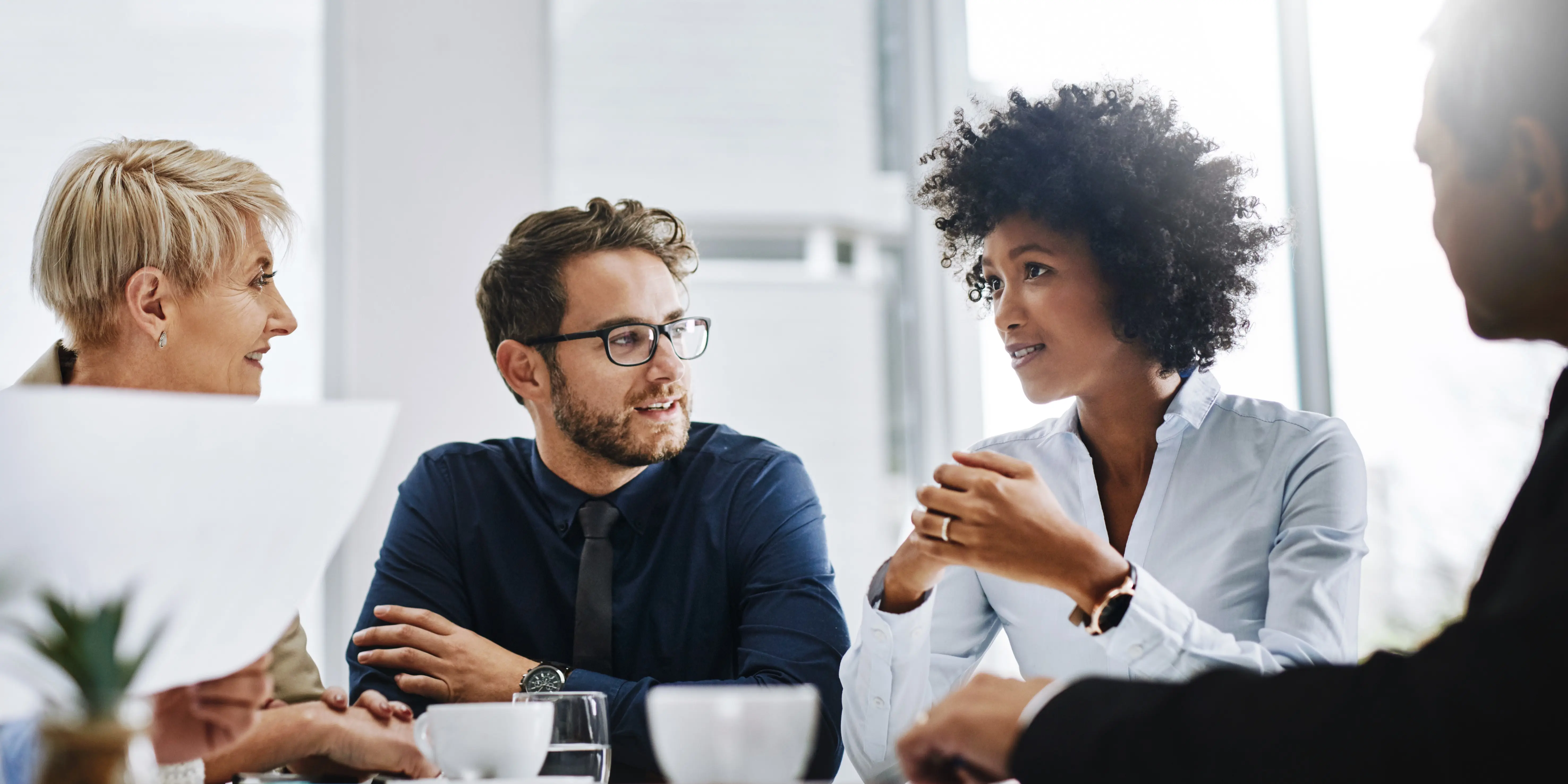 Diverse business team discussing documents in a bright office.