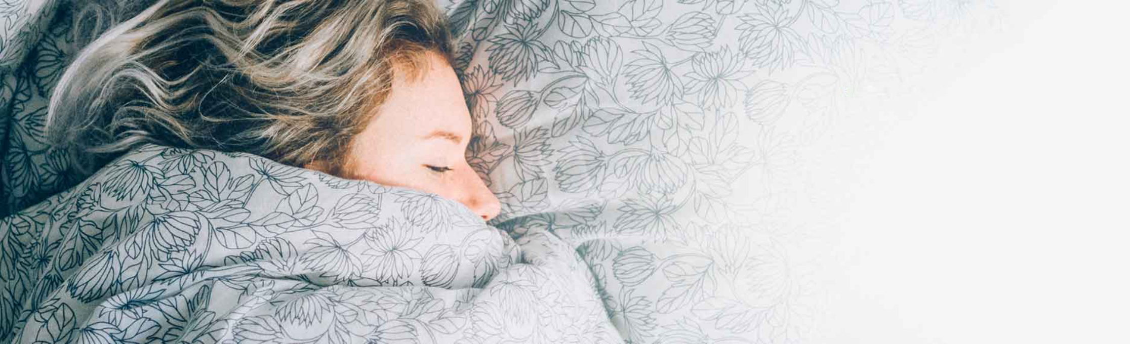 Woman sleeping wrapped in a blanket