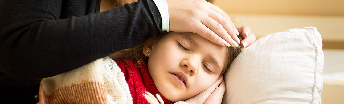 Madre controlando la temperatura de su hija enferma