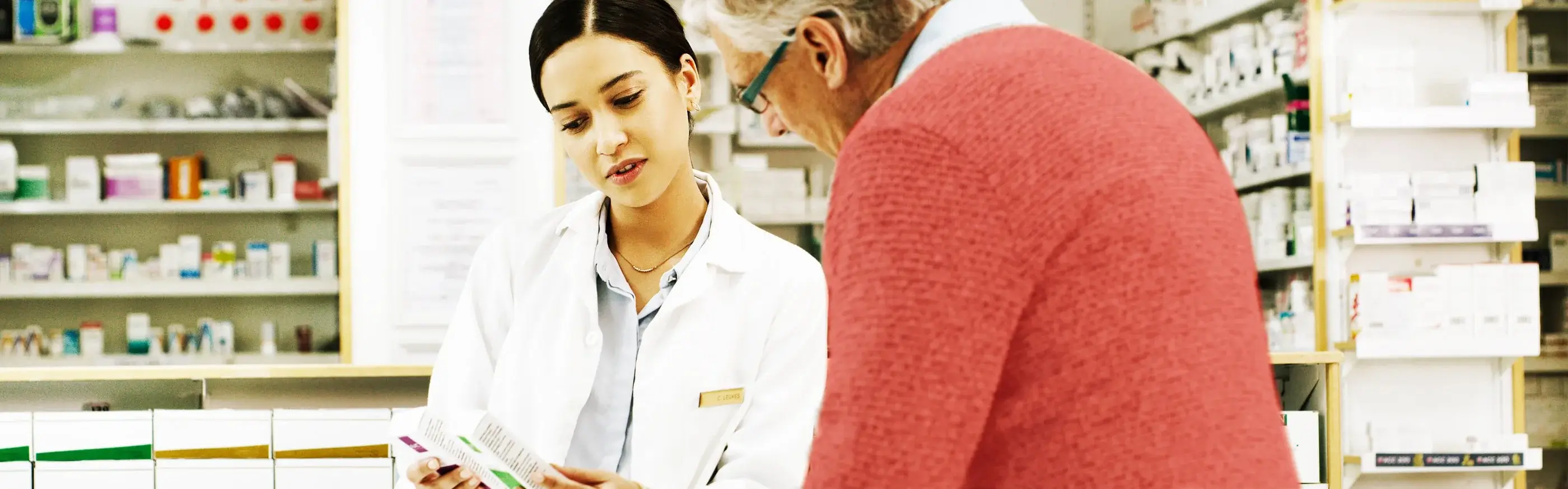 Pharmacist showing behind-the-counter medicine to a patient