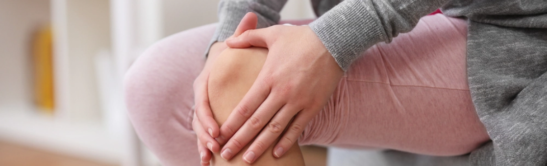 Person on white shirt experiencing arthritis pain