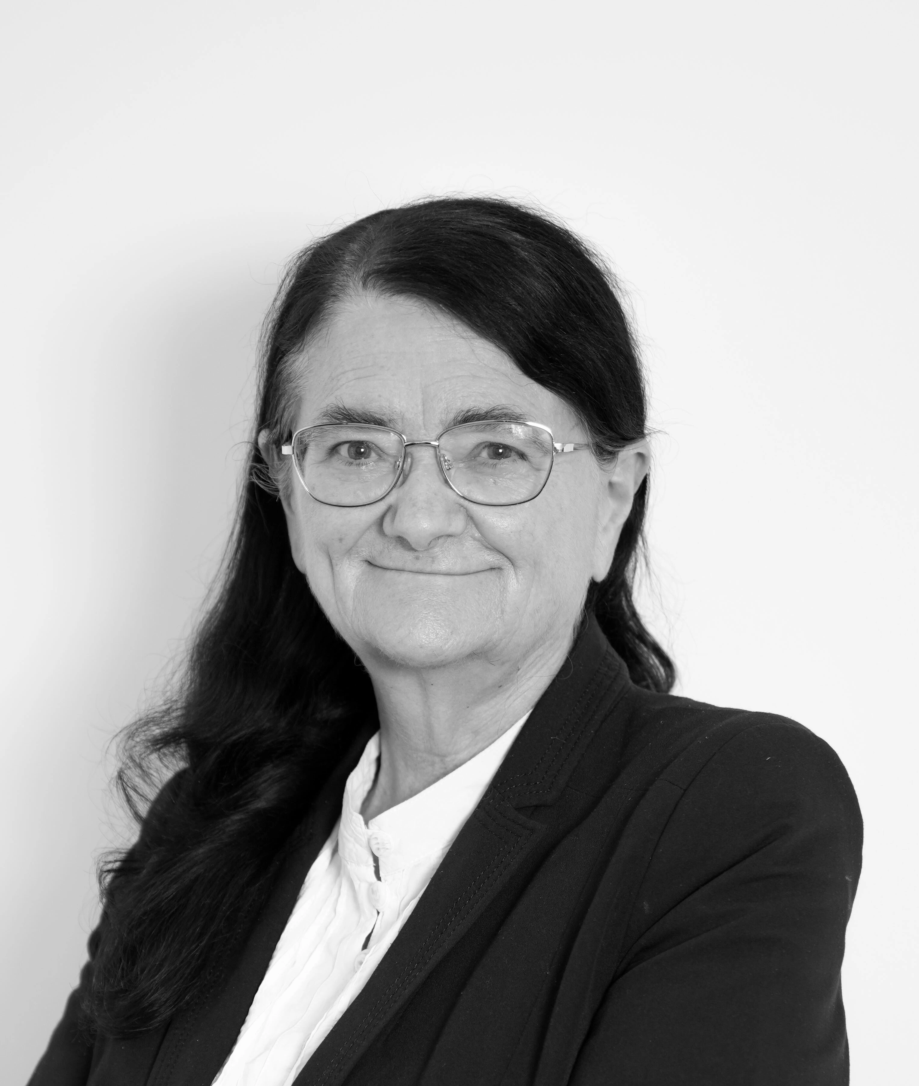 a black and white photo of Professor Sara Chandler KC (Hon) wearing glasses and smart business attire.