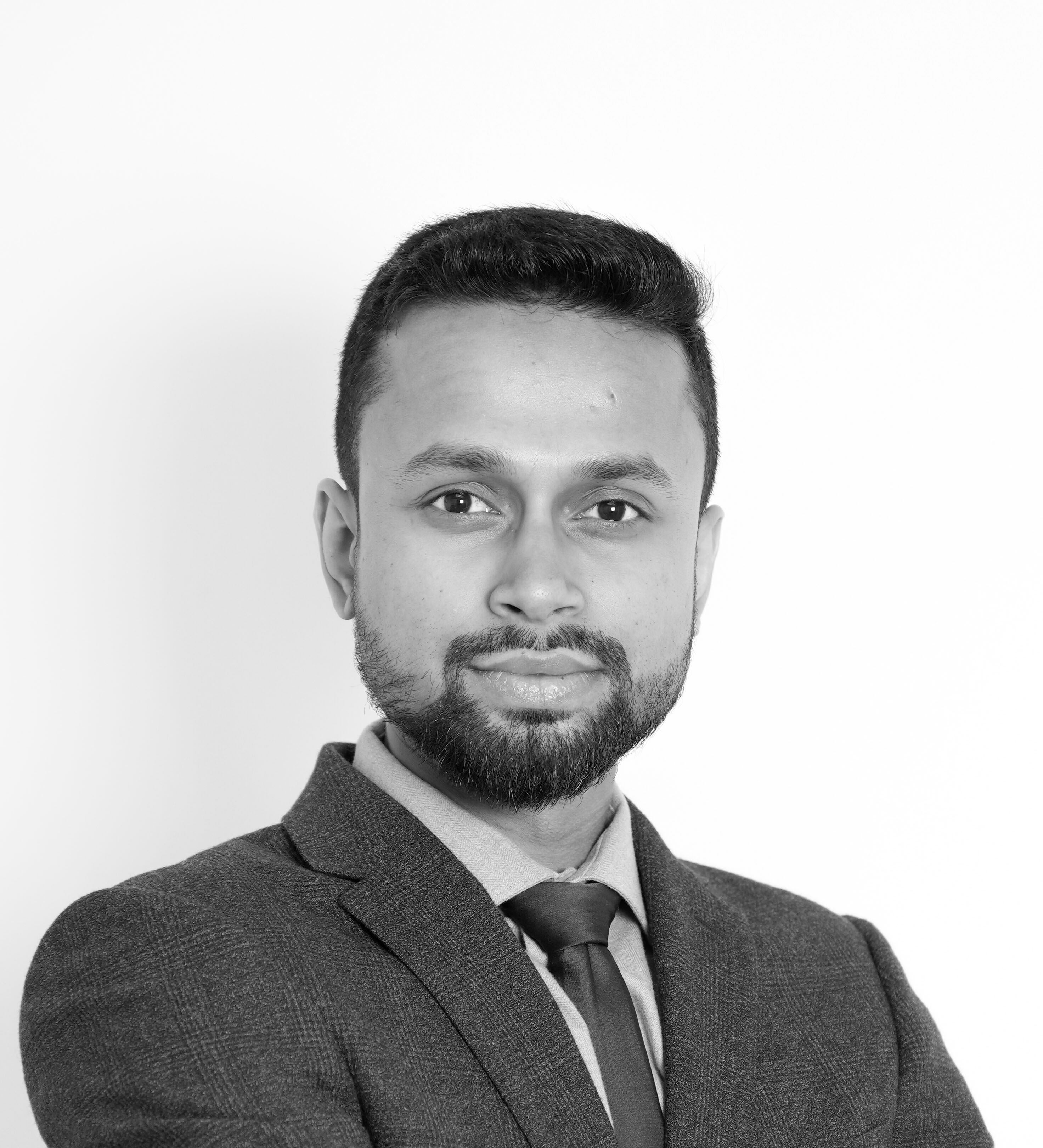 A black and white photo of Aman Ali in a business suit.